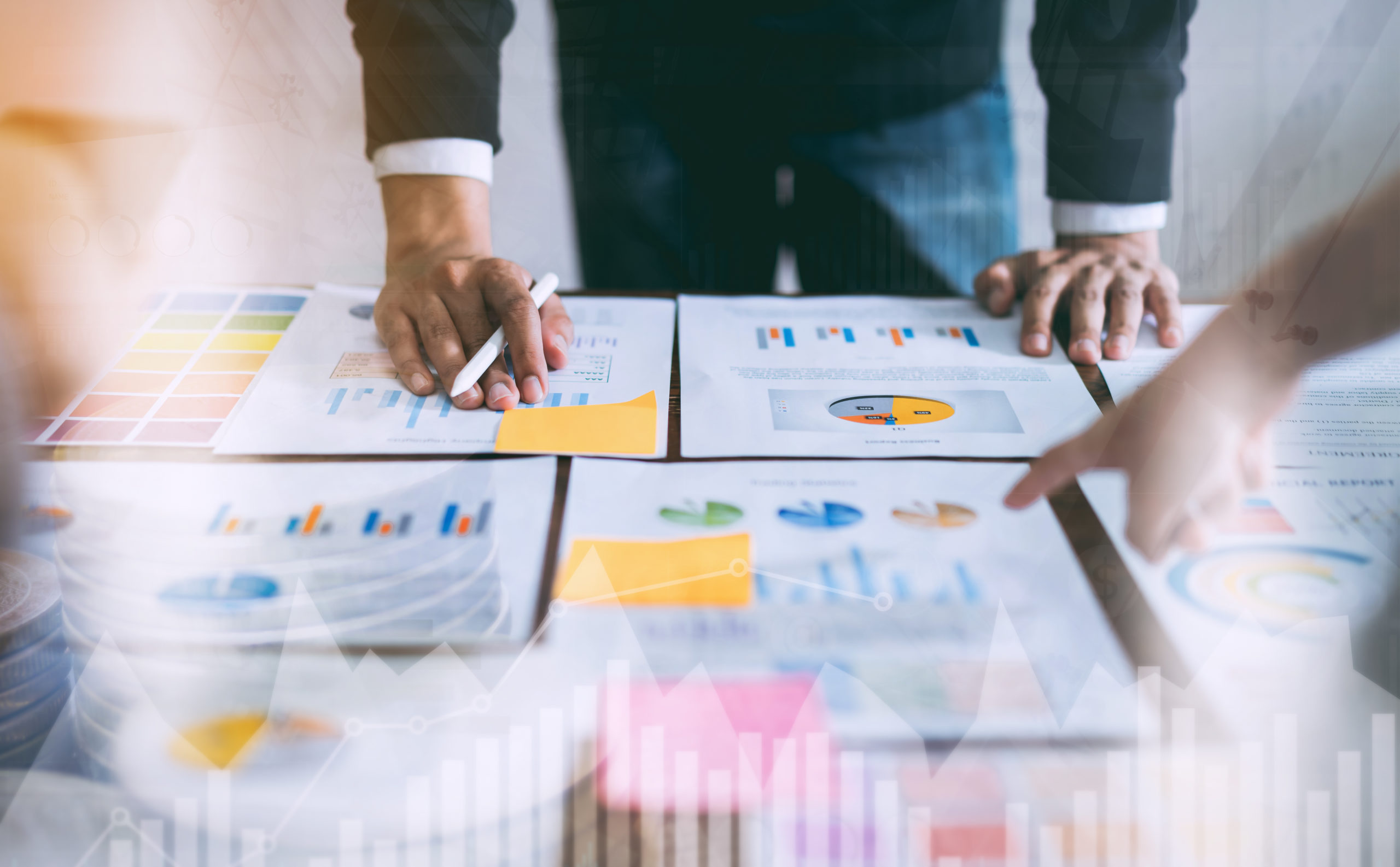 double exposure of business people meeting team working on wooden desk and hand man pointing to financial documents in office. successful meeting workplace strategy.