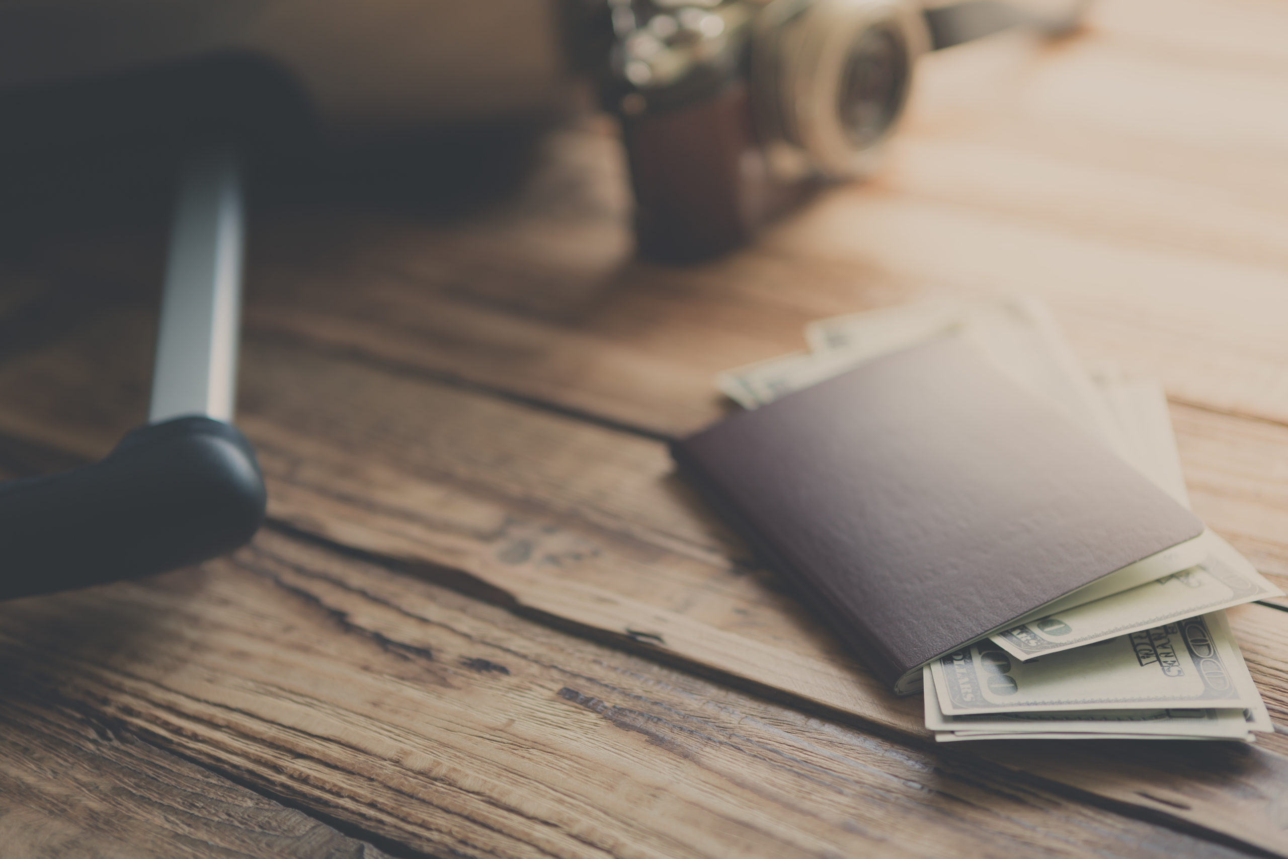 Blank passport and camera with US dollars on wood table ( Filtered image processed vintage effect. )